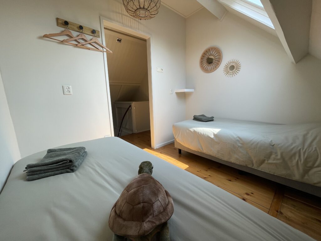Slaapkamer met twee enkele bedden in Vakantiehuis De Zeerob in Lauwersoog.